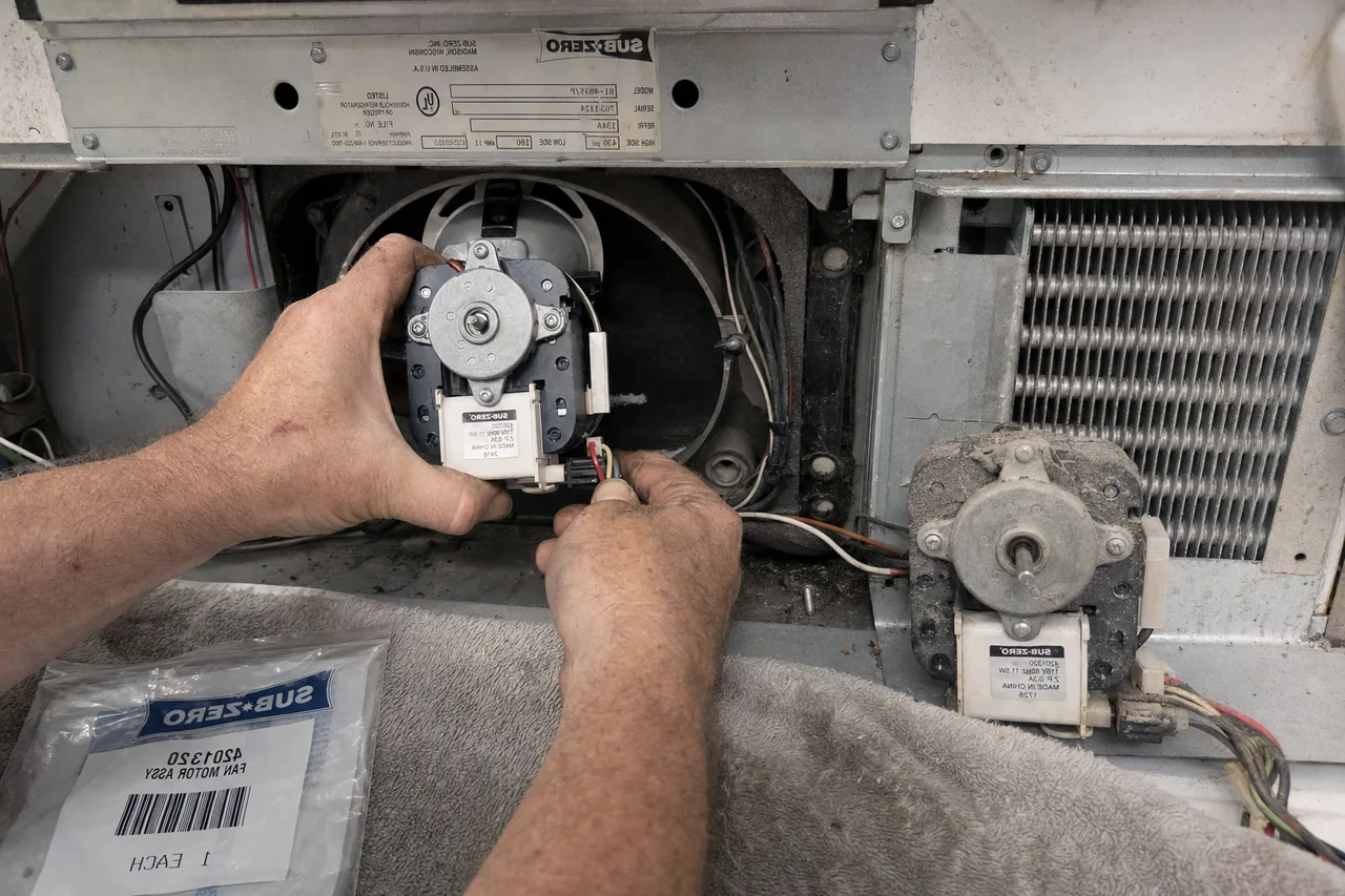Close-up of a replacement part being fitted to a refrigerator